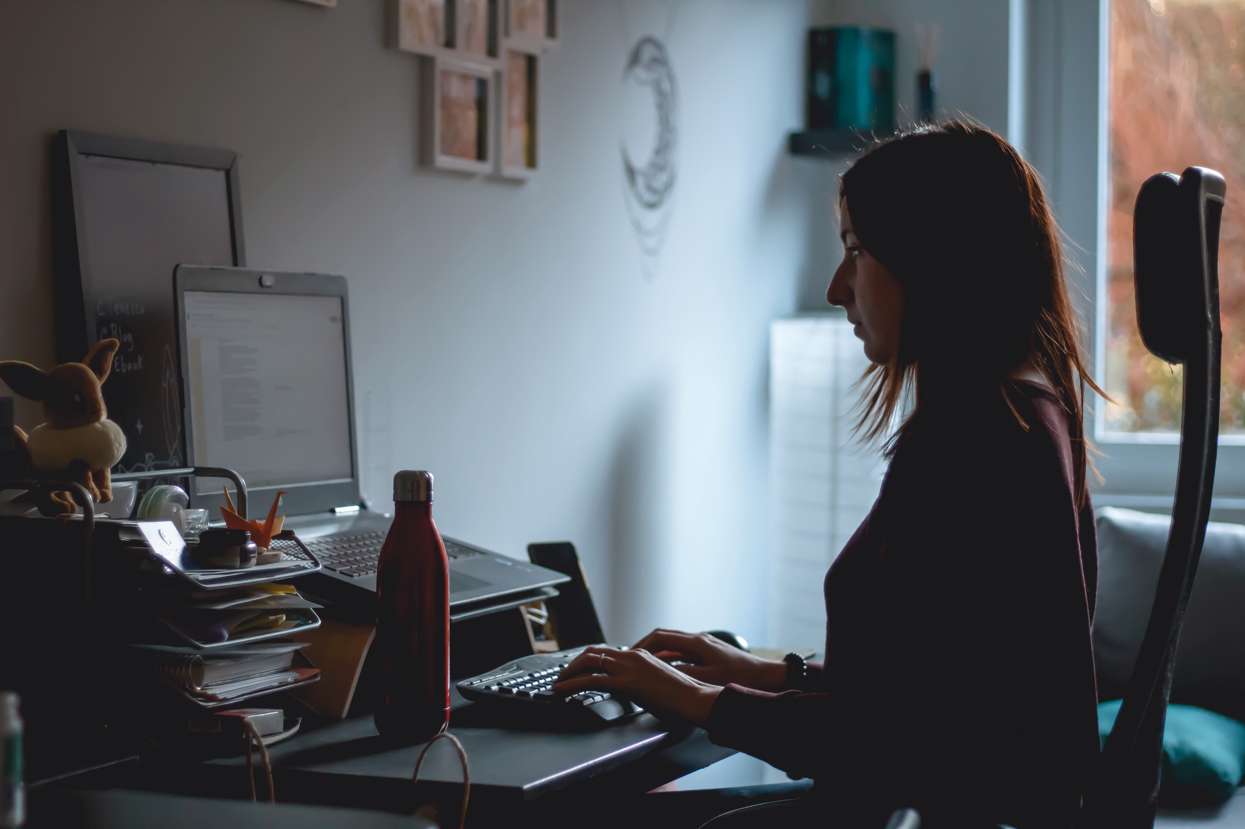 person sitting at laptop in a dark room